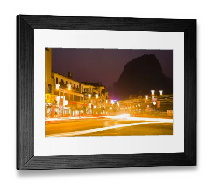 Framed Print : China, Guangxi Zhuang Autonomous Region, Yangshuo City. Busy traffic running through a chinese city at night with a backdop of limestone Framed Print : China, Guangxi Zhuang Autonomous Region, Yangshuo City. Busy traffic running through a chinese city at night with a backdop of limestone