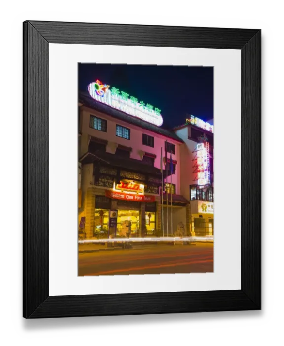 Framed Print : China, Guangxi Zhuang Autonomous Region, Yangshuo City. Busy traffic running through a chinese city at night with a backdop of limestone