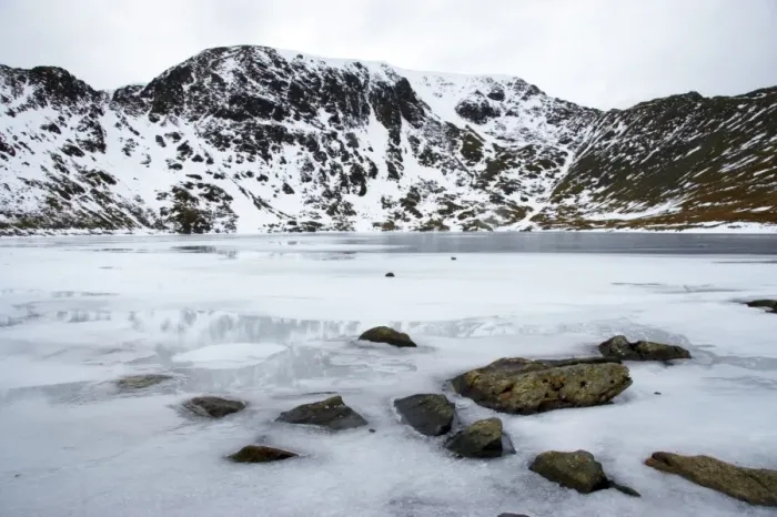 Framed Print : England, Cumbria, Lake District National Park. Rocks and the ice covered expanse of Red Tarn