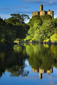 England, Northumberland, Warkworth. Warkworth Castle reflected in the still waters of the River Coquet